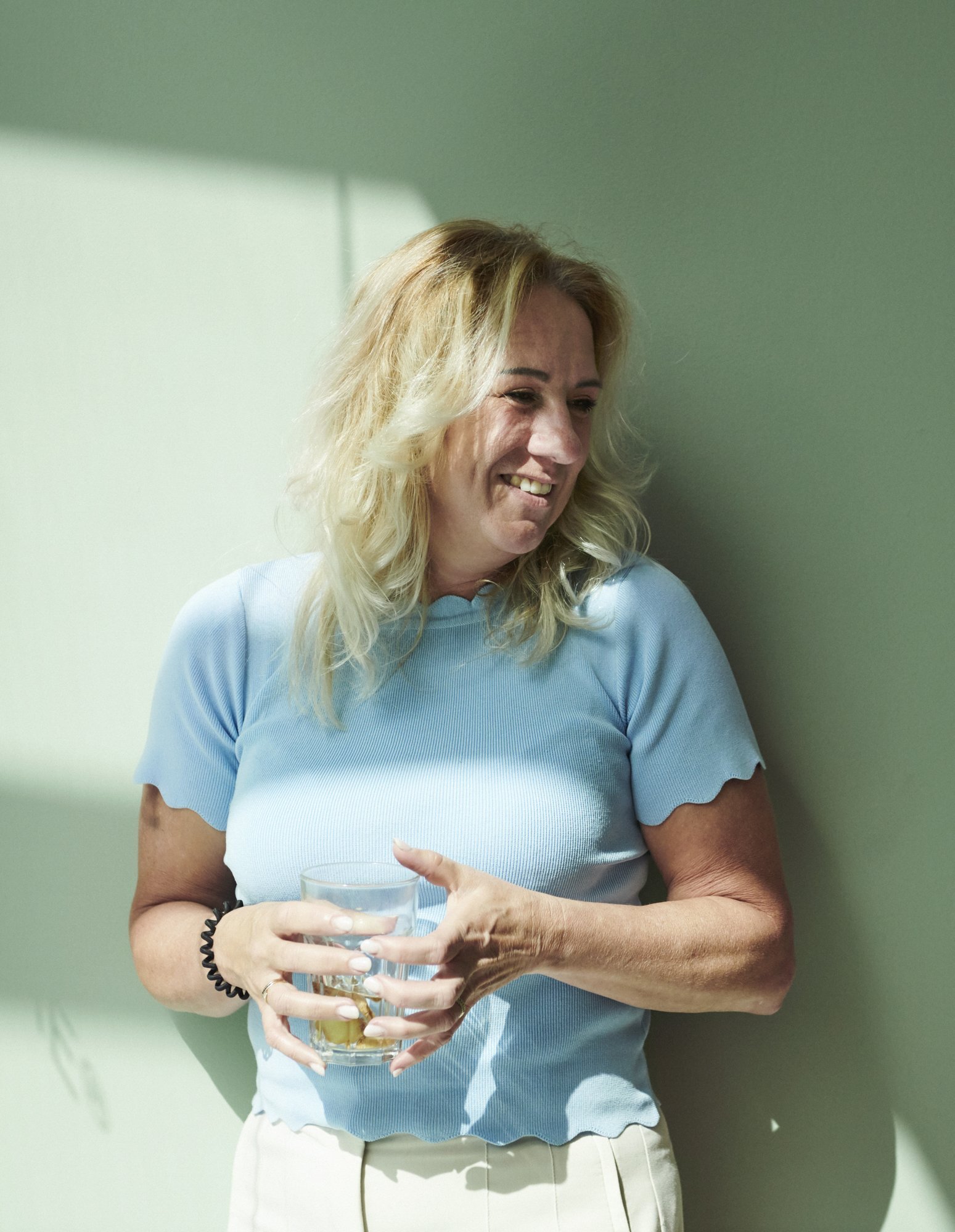 Lachende vrouw met een glas in de hand