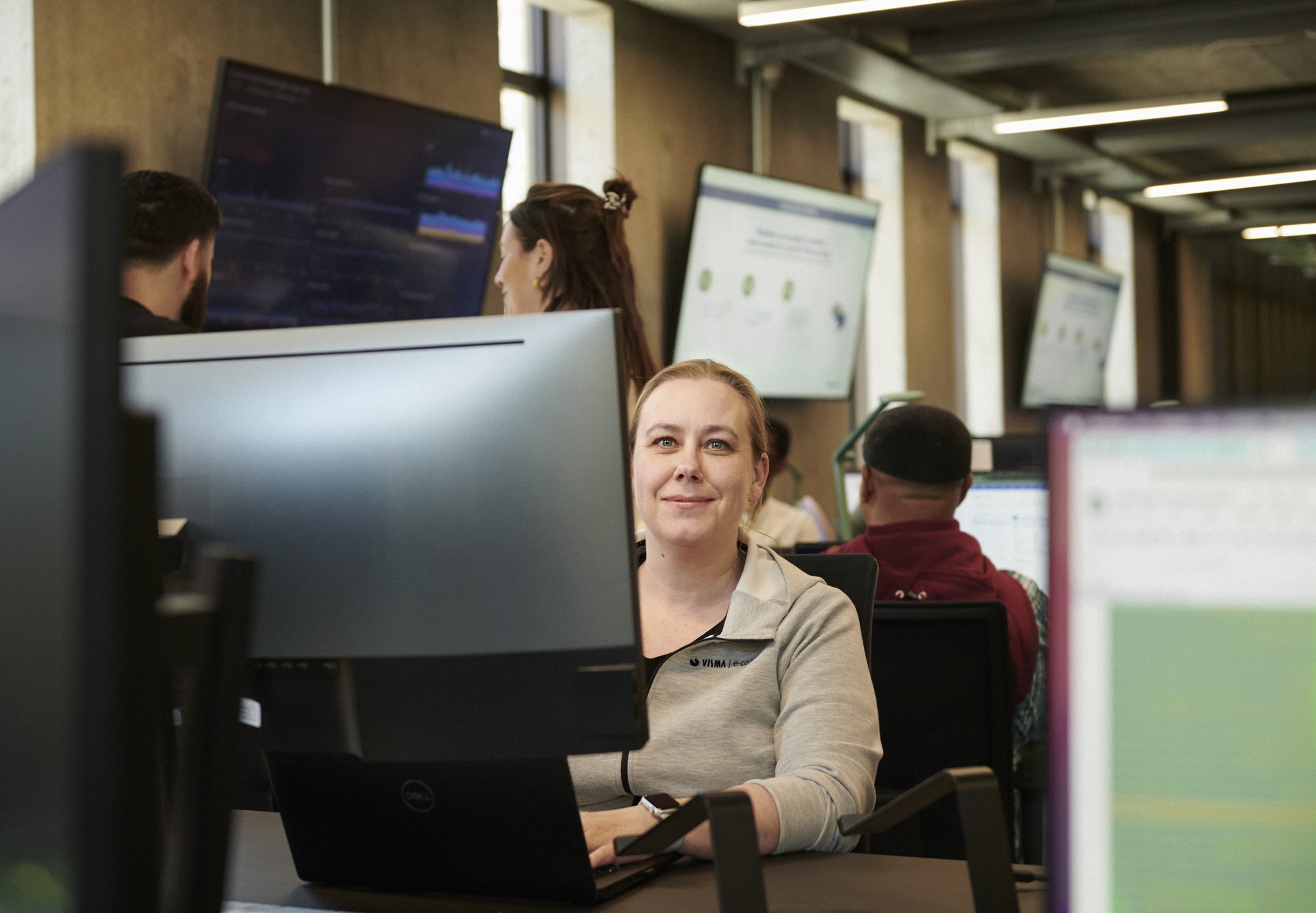Medewerker aan haar werkplek met beeldschermen